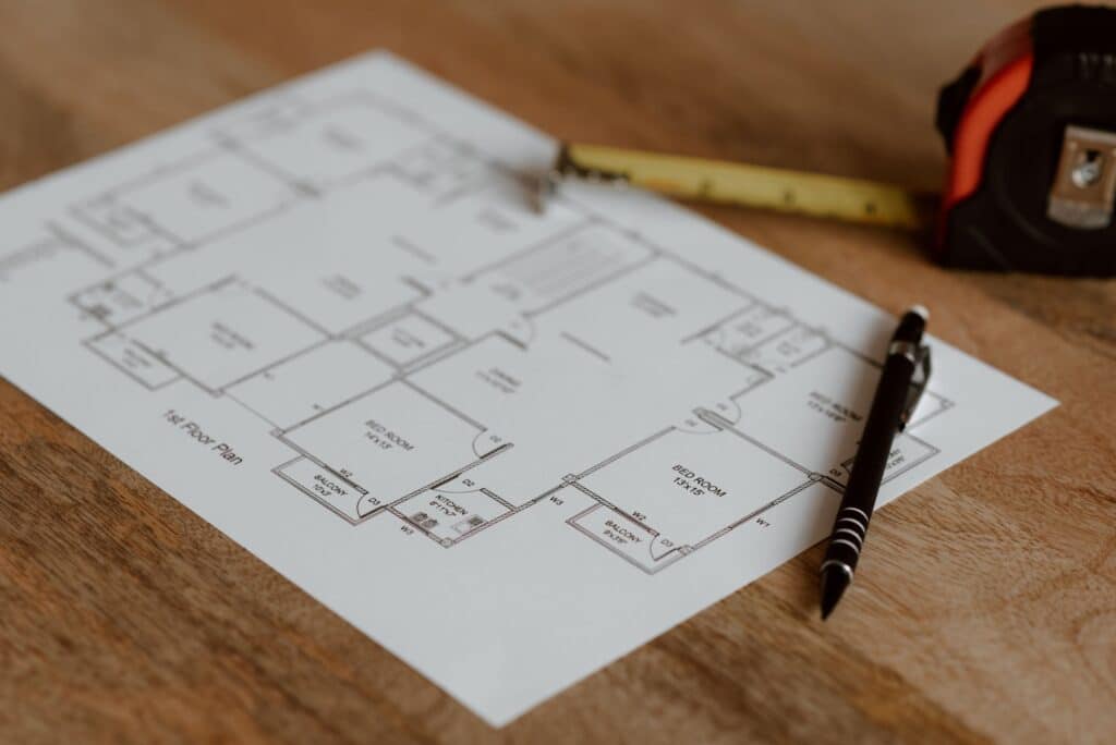 Architectural blueprint with a pen on a wooden desk