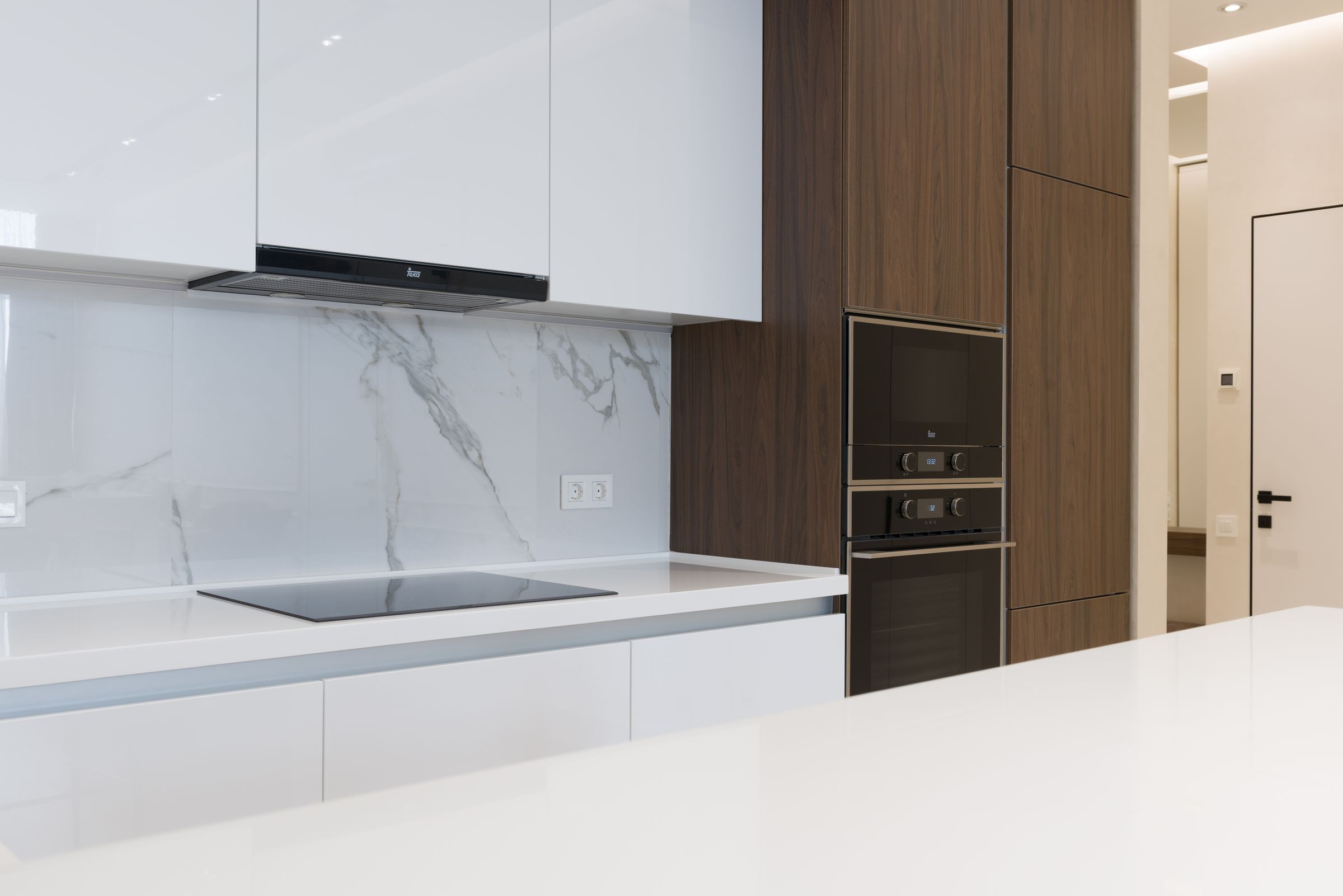Contemporary kitchen with white cabinetry and timber detailing