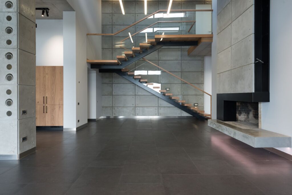 Steel and timber stair detail against a concrete wall in low light