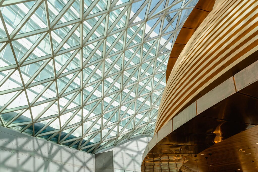 Glass atrium with a curved timber structure and layered daylight