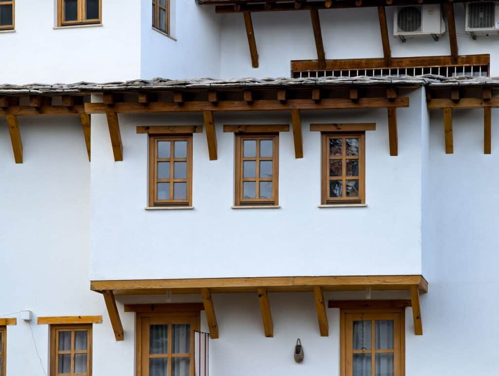 White house exterior with timber-framed windows and a deep eave