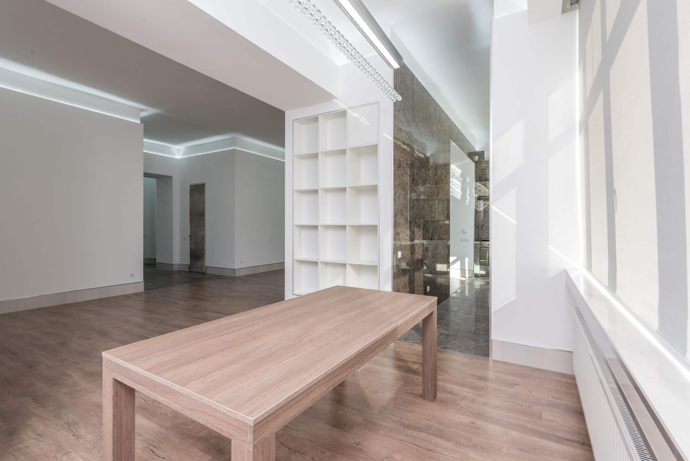 Bright minimalist interior with a long timber table and natural light