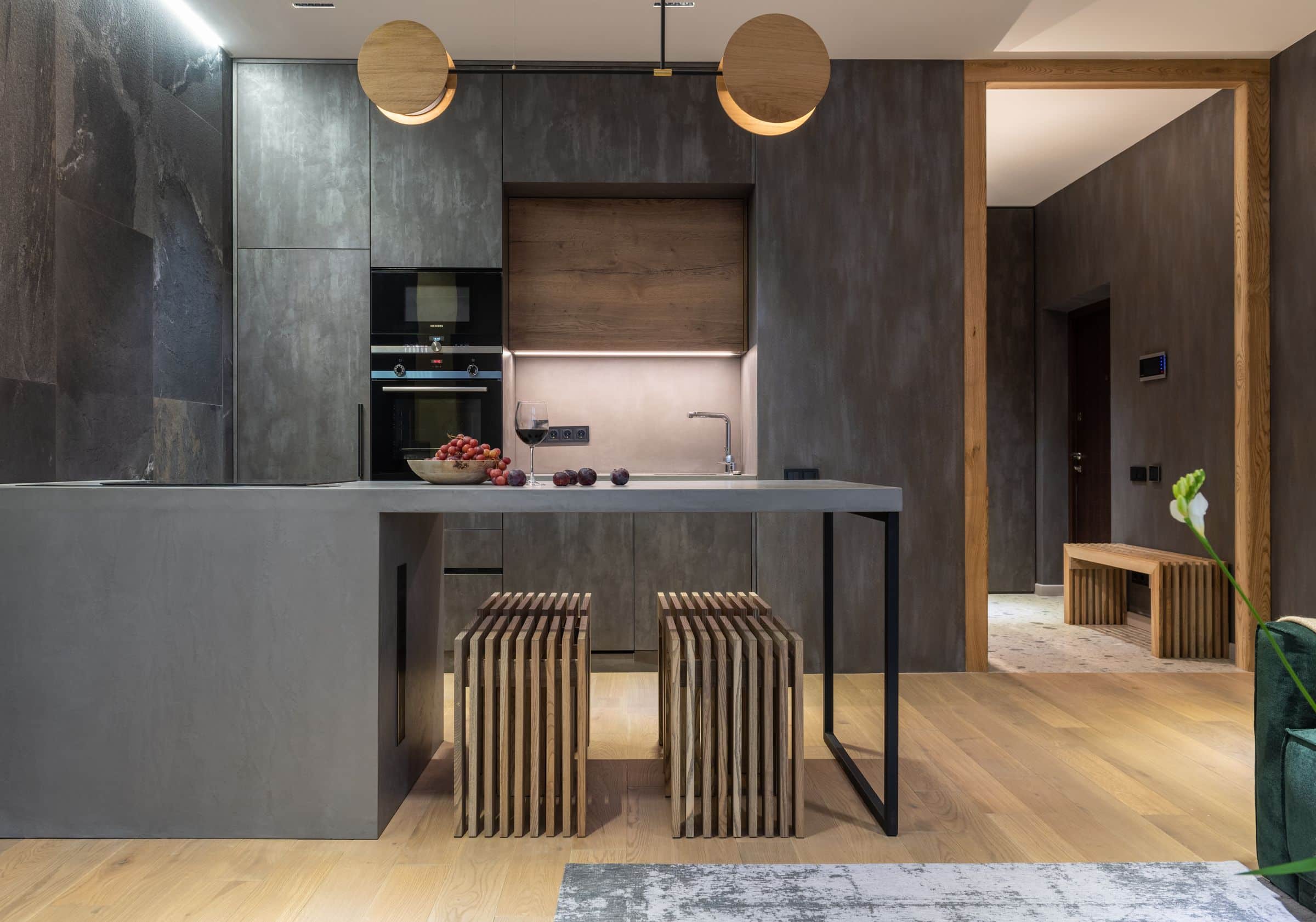 Modern kitchen with warm wood cabinetry and stone counters in low ambient light
