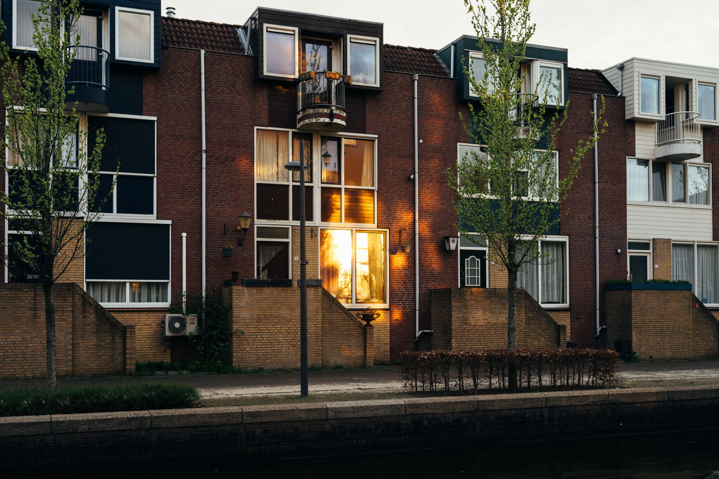 Row of modern townhouses reflecting warm dusk light