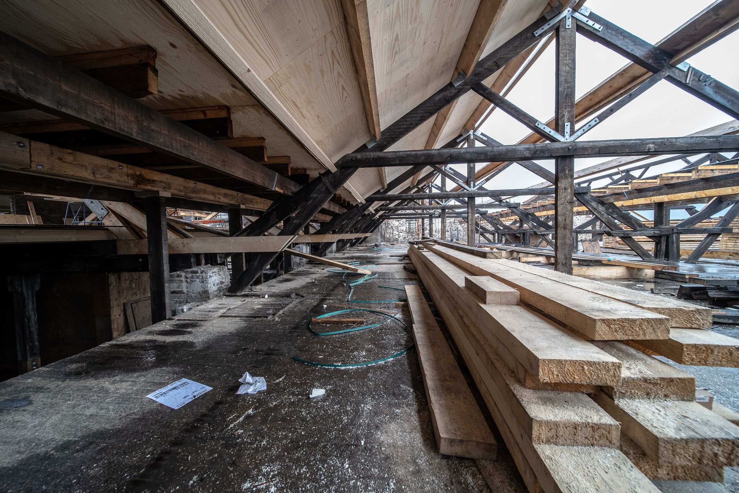 Timber and steel roof structure in progress against open sky