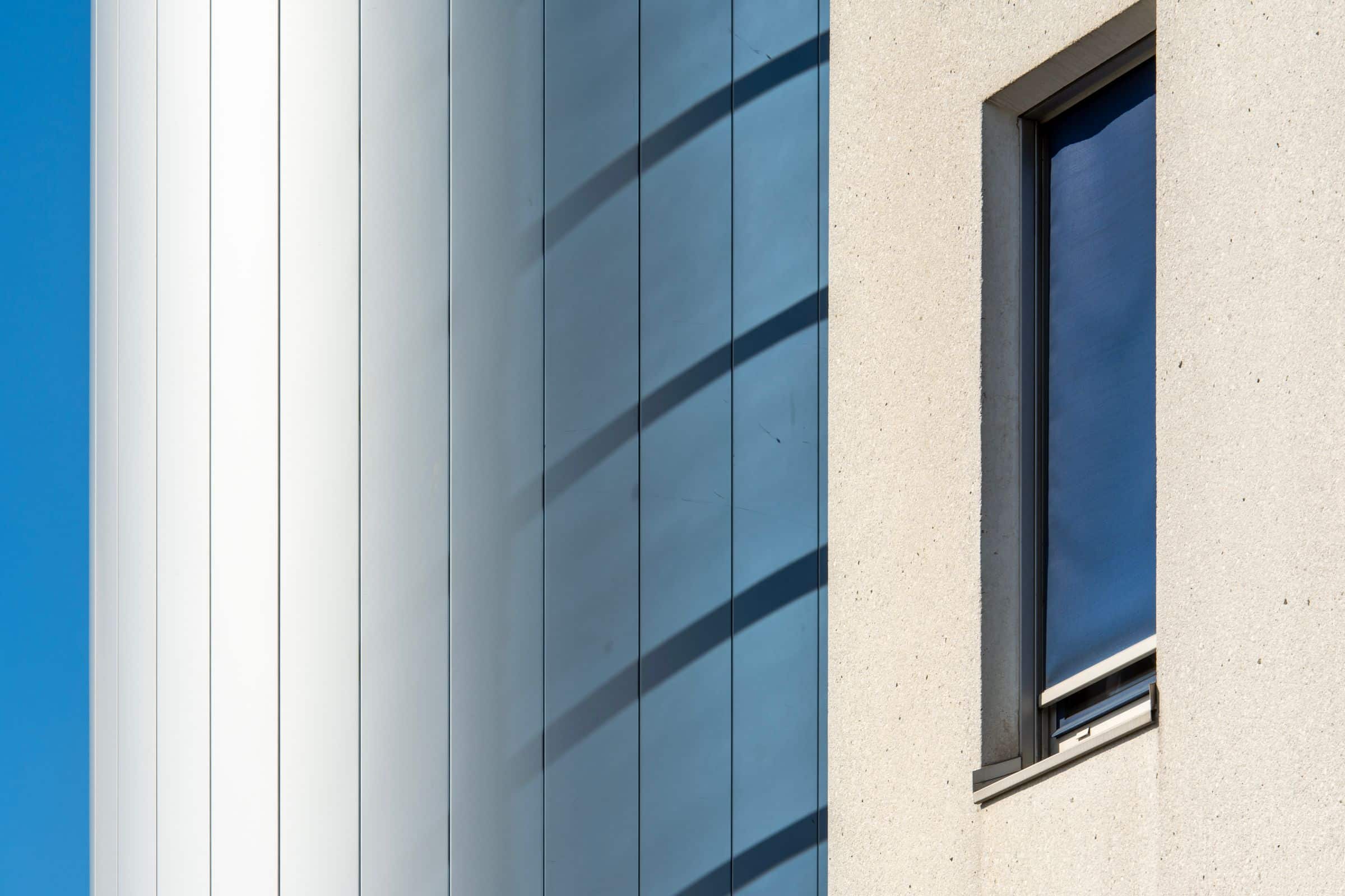 Angled facade with glazed bays and concrete panels