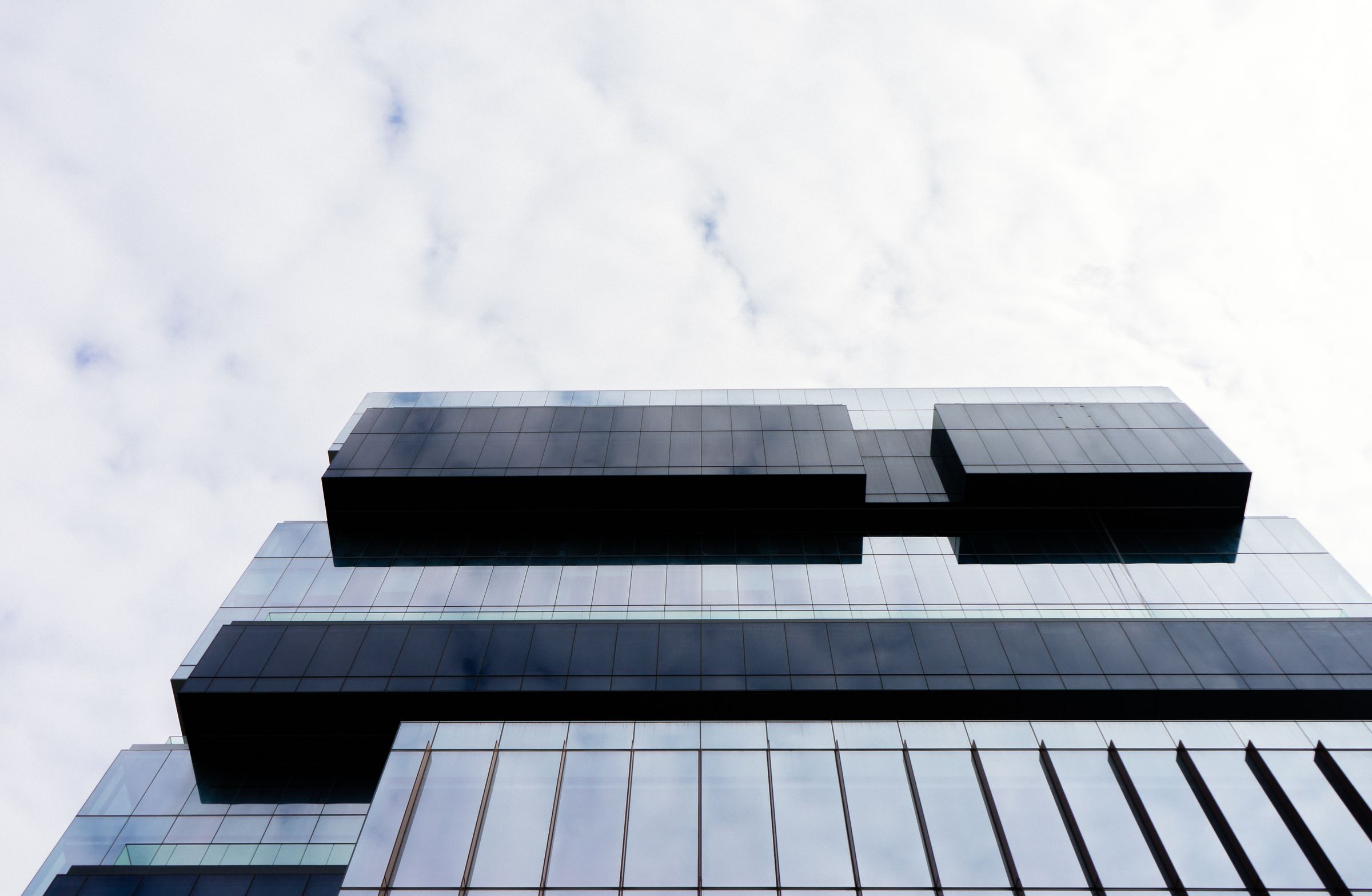 Cantilevered dark building volumes against an open sky