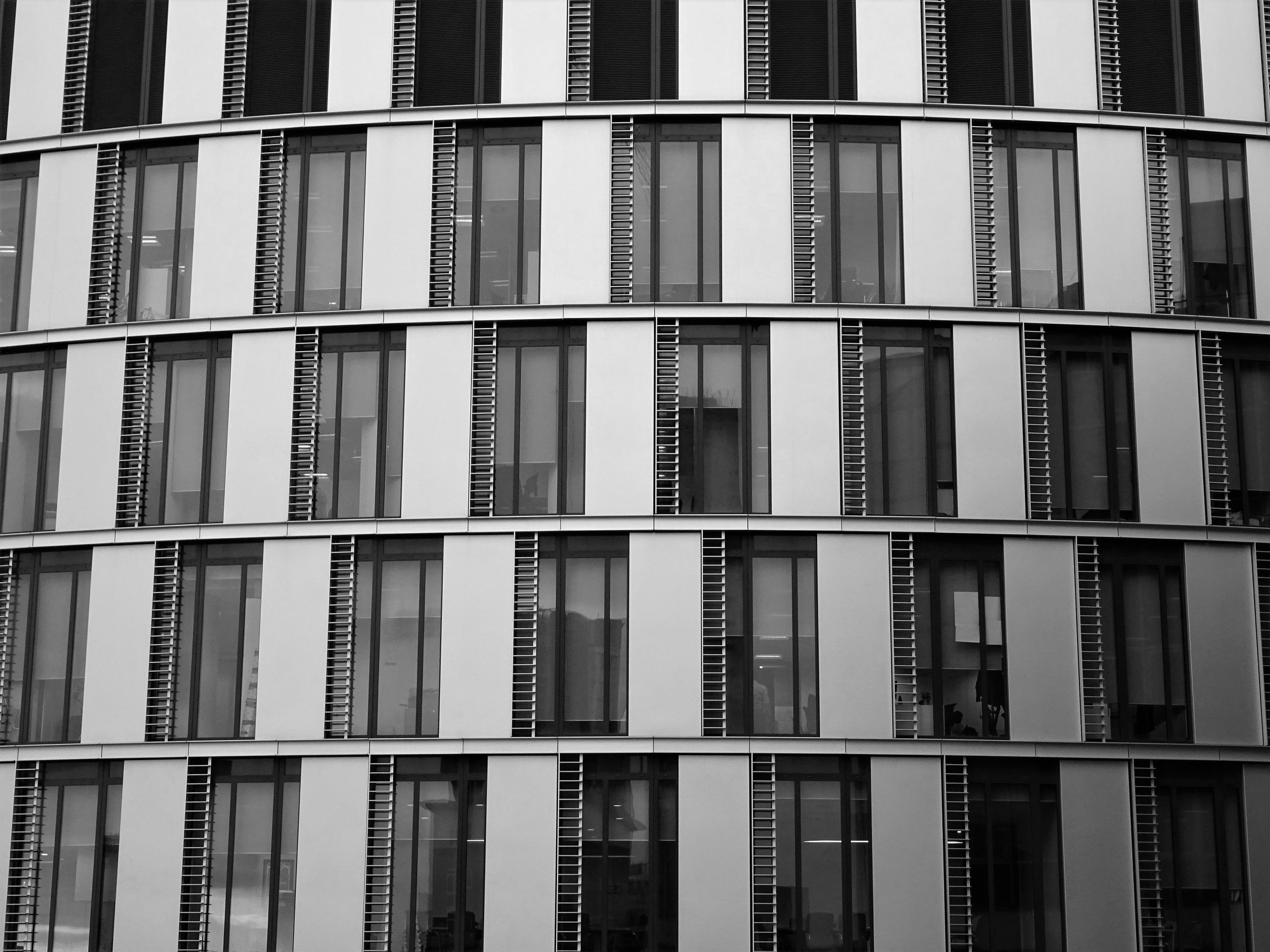 Rhythmic facade of repeating window bays in monochrome