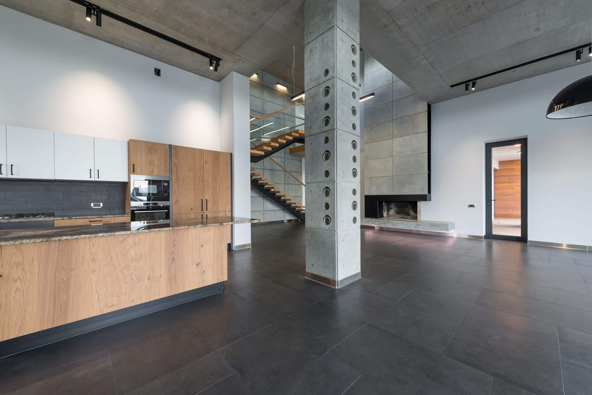 Open-plan contemporary interior with concrete ceilings and timber cabinetry
