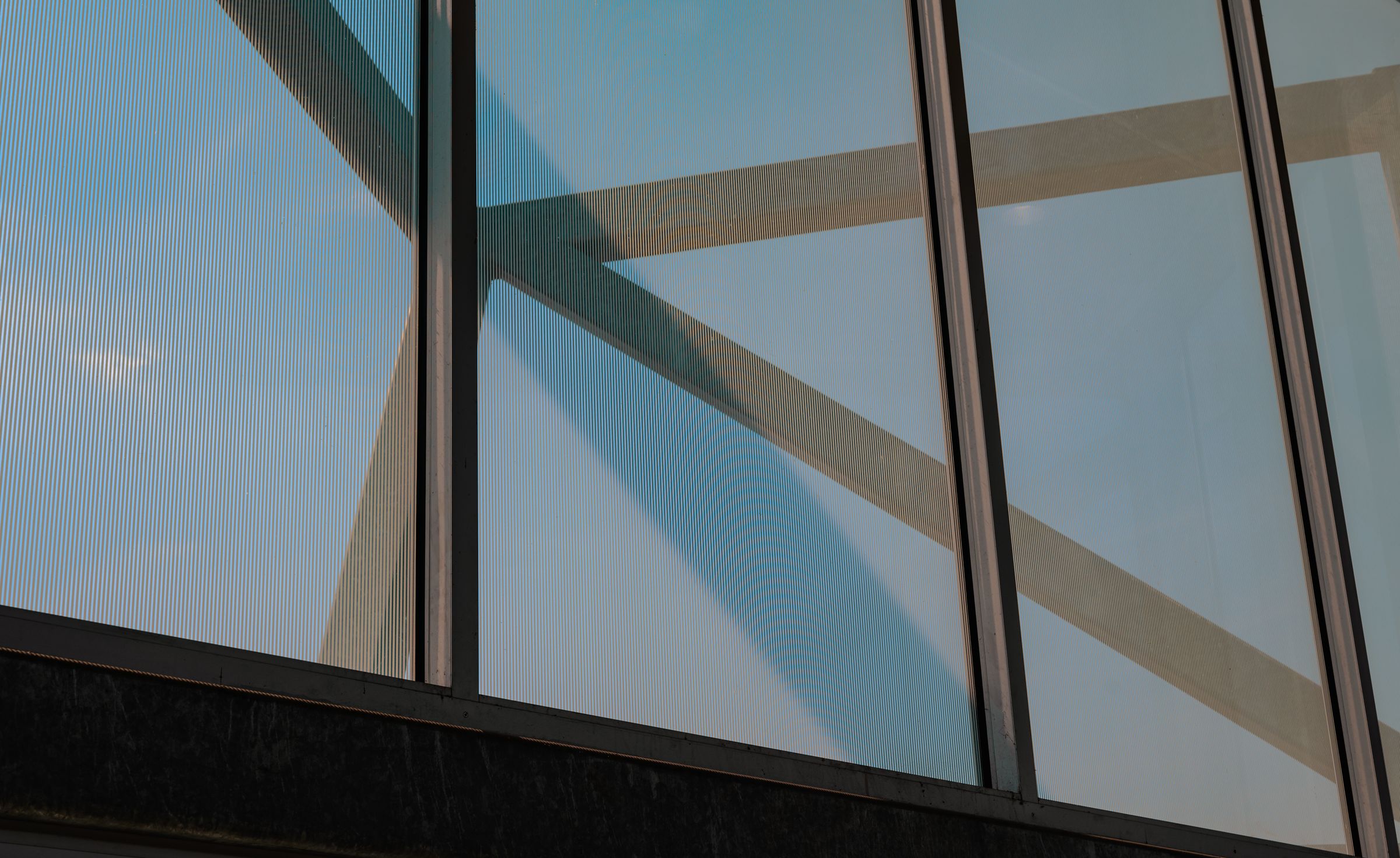 Abstract view of glass facade panels with diagonal structural reflections