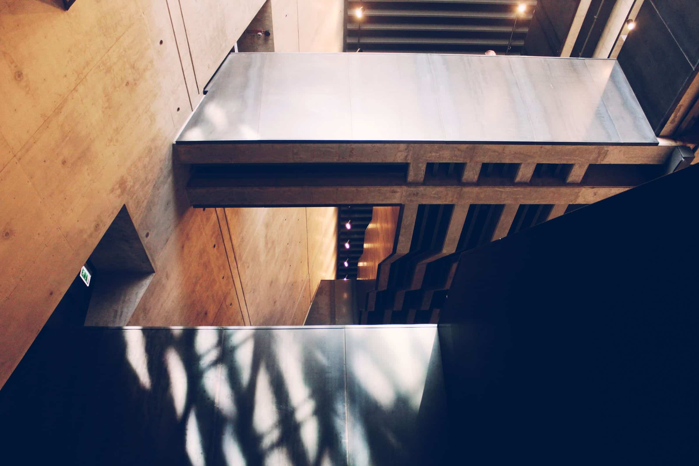 Abstract play of light and shadow across timber and concrete interior surfaces