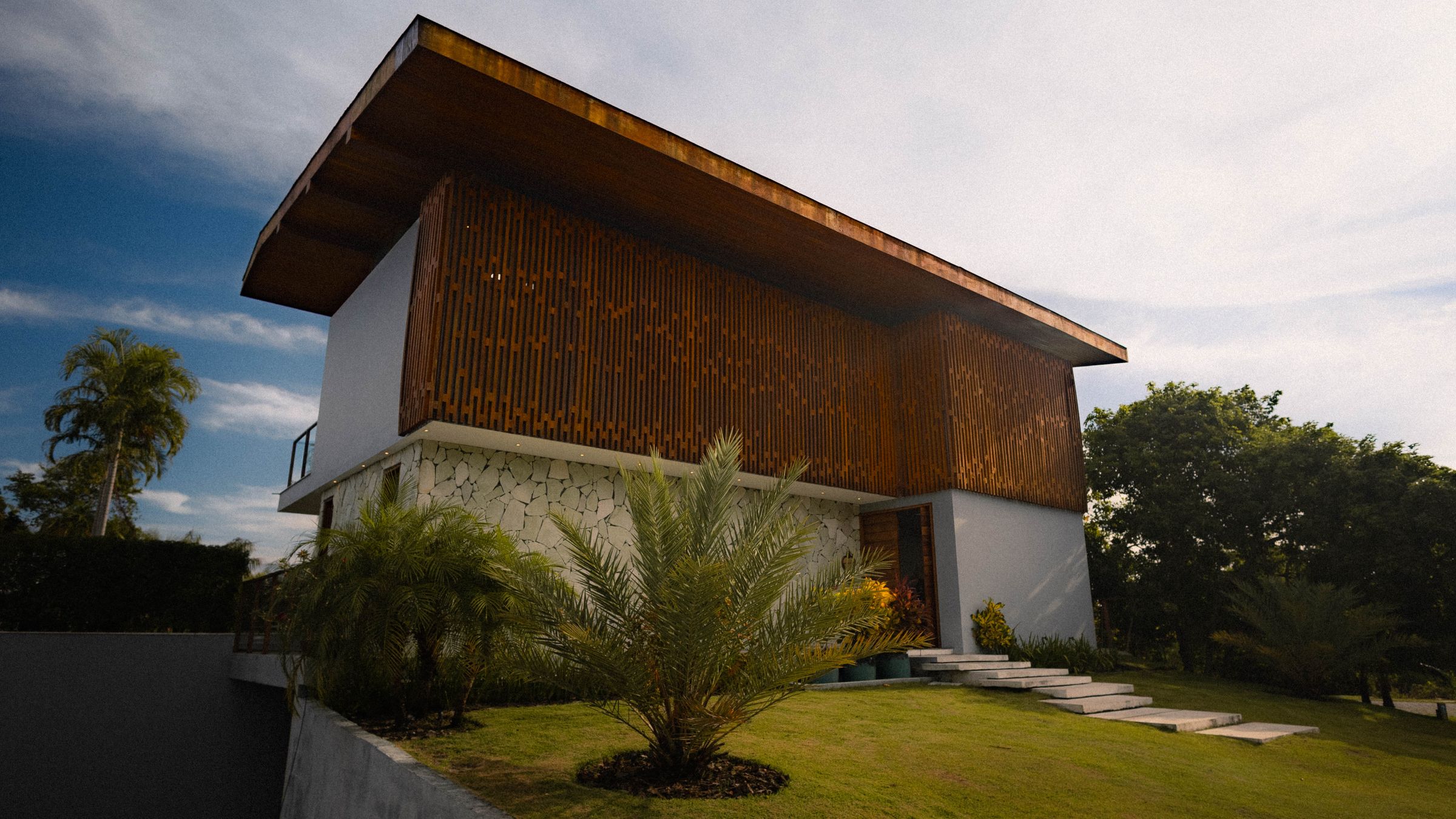 Timber-clad residence facade with deep roof overhang against an open sky