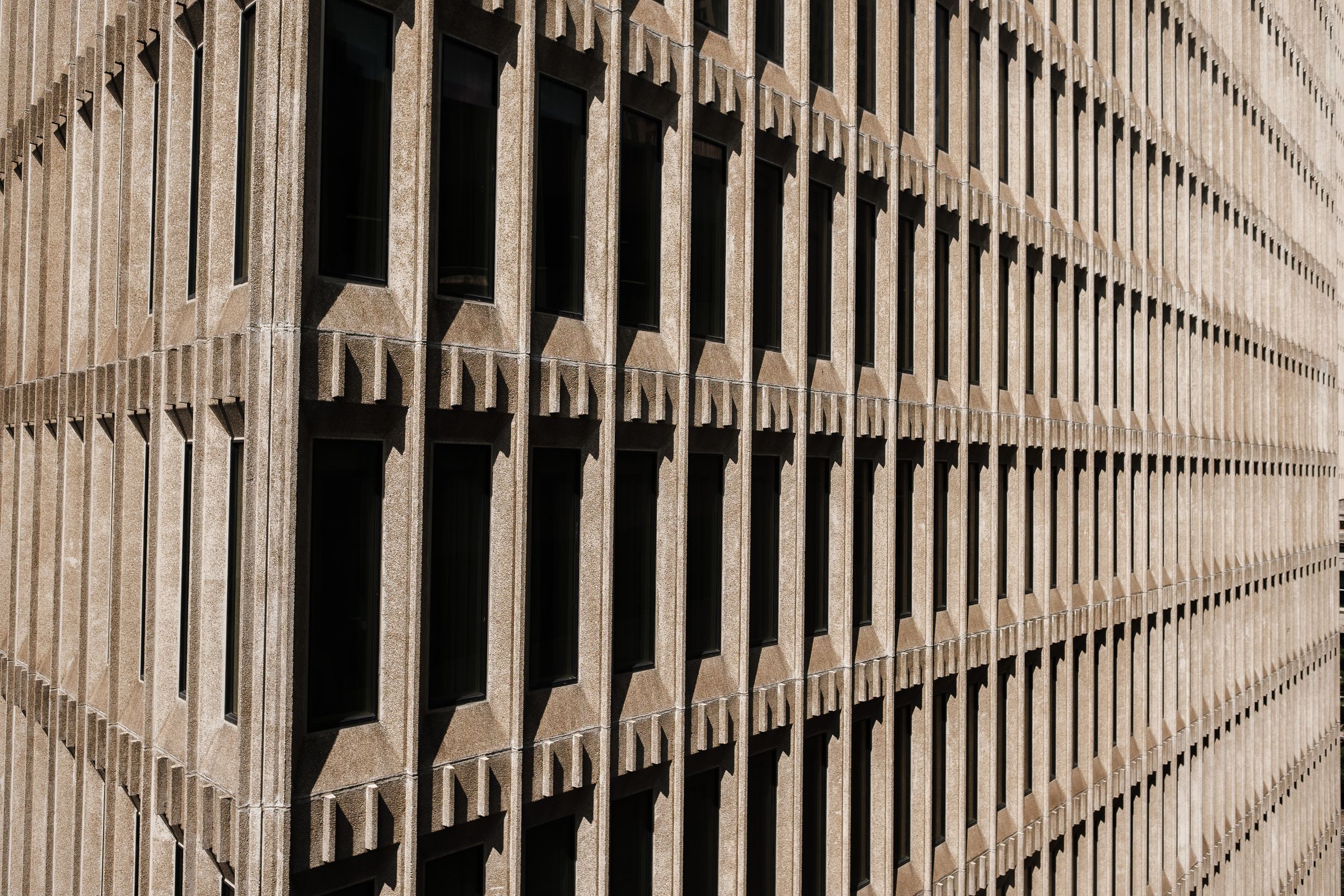 Repetitive concrete fin facade creating light and shadow geometry