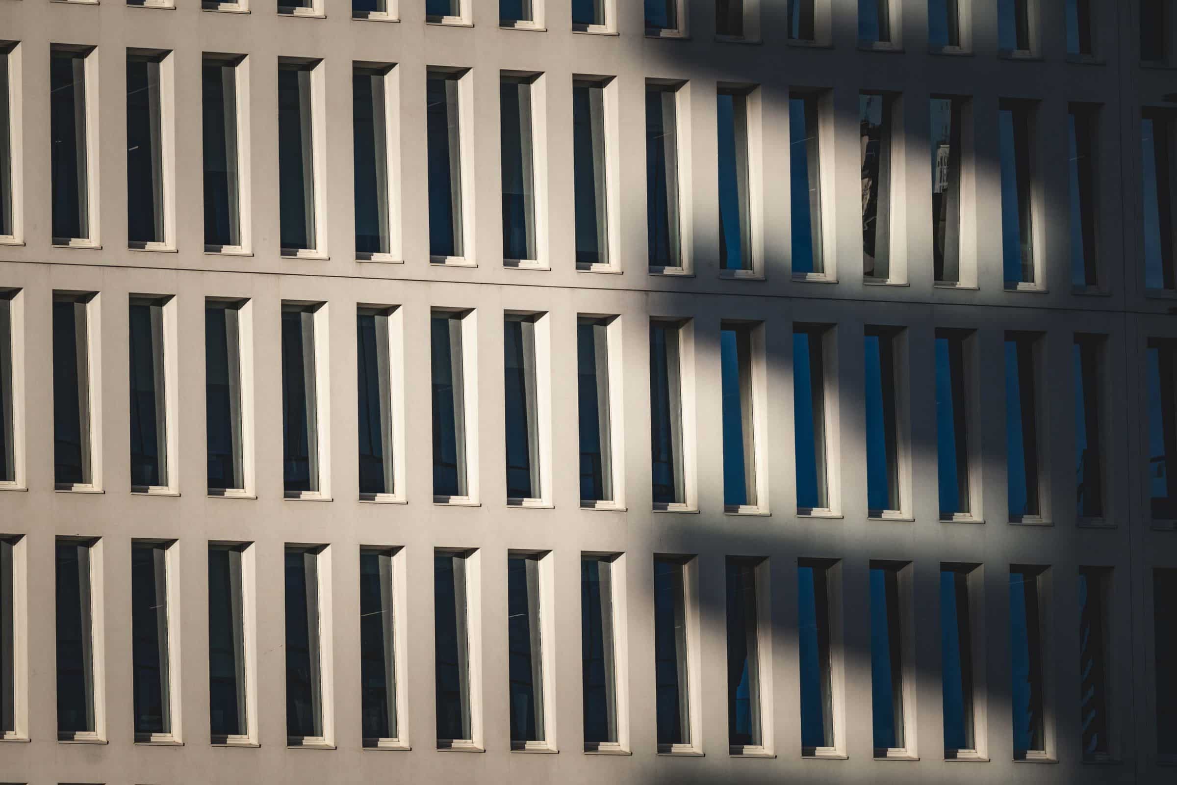Modern building facade with deep window reveals and dramatic shadow lines