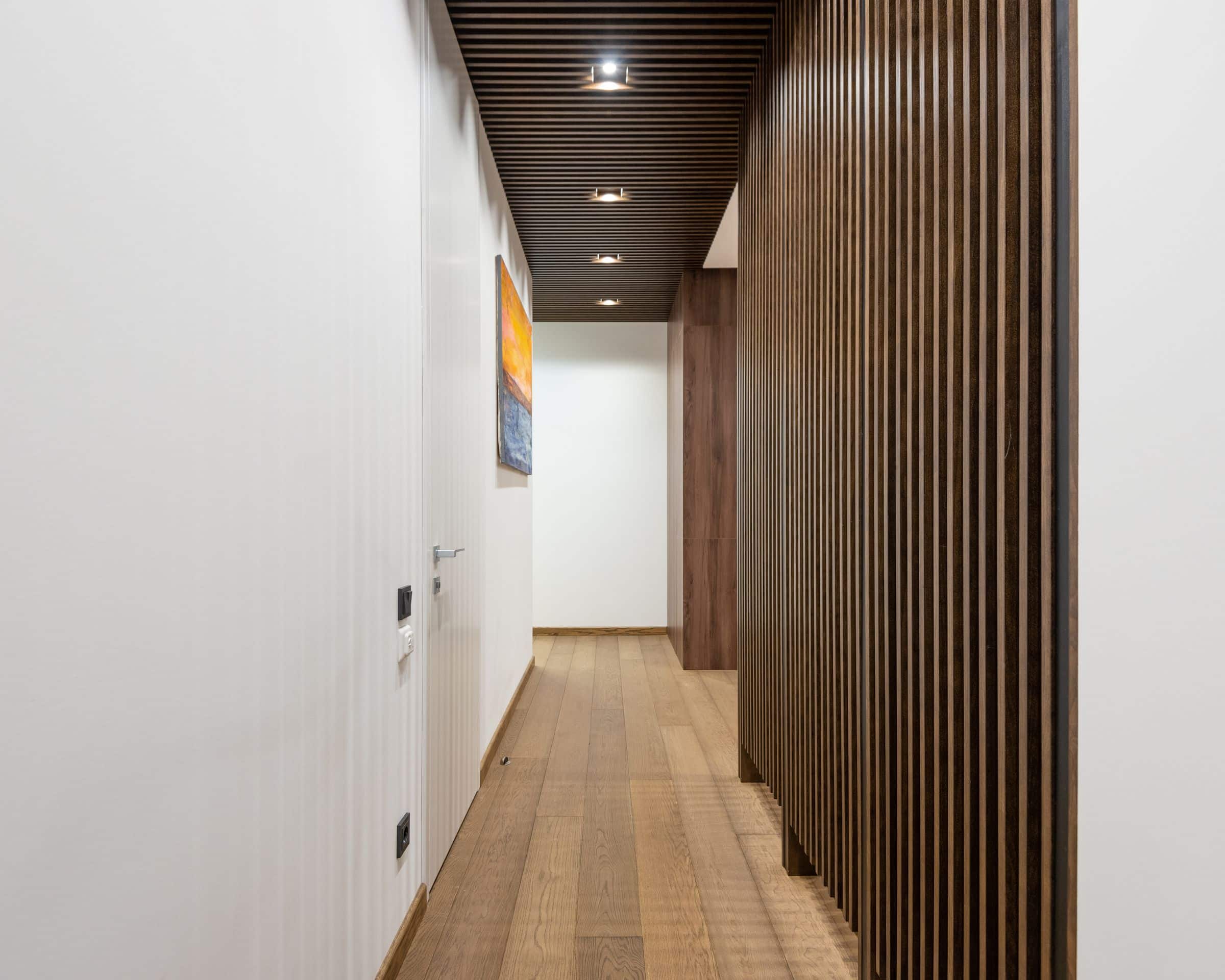 Minimal hallway with timber slat panelling and soft architectural light