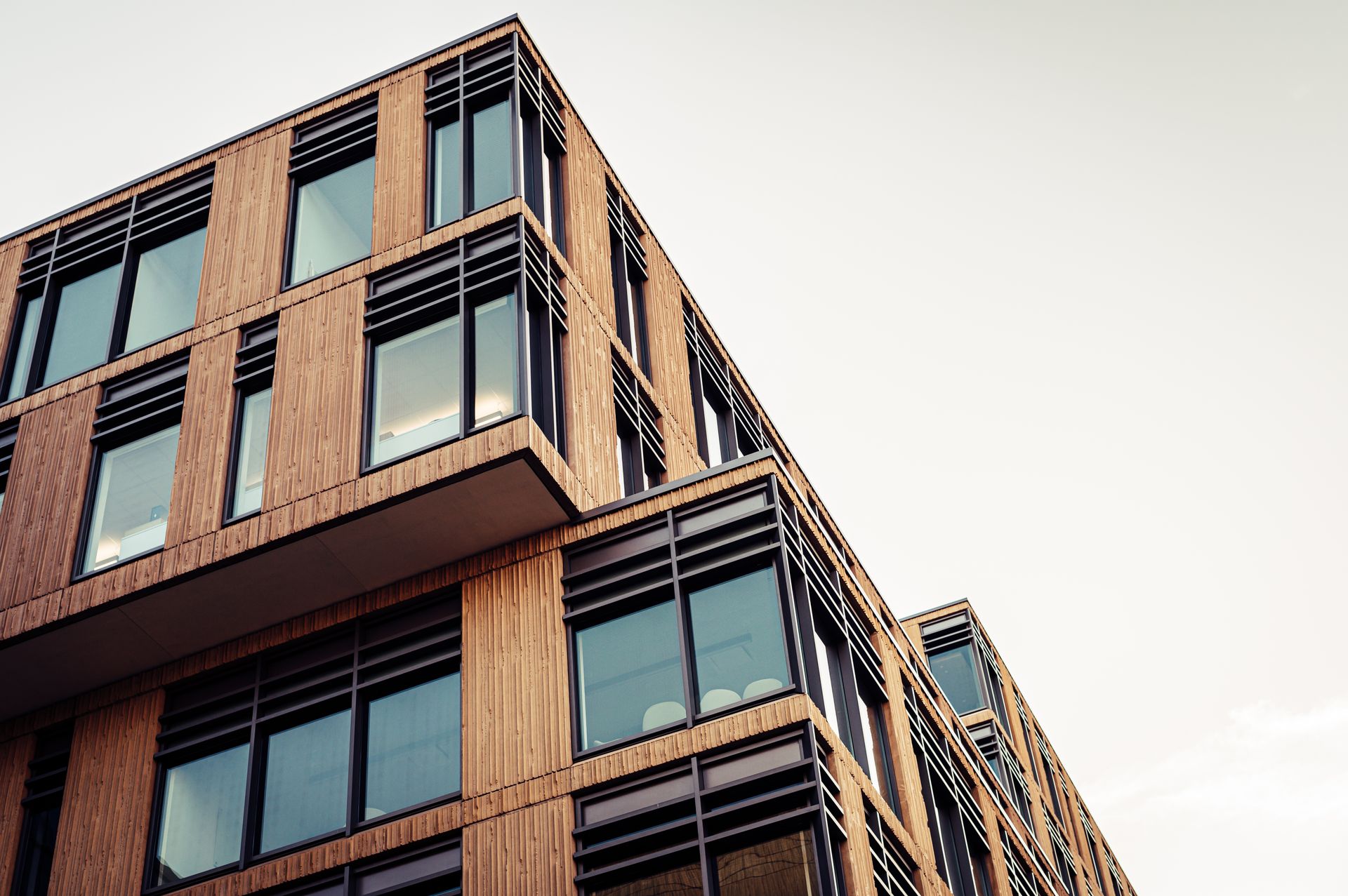 Commercial building with timber-slat facade and dark-framed glazing — representative commercial architecture